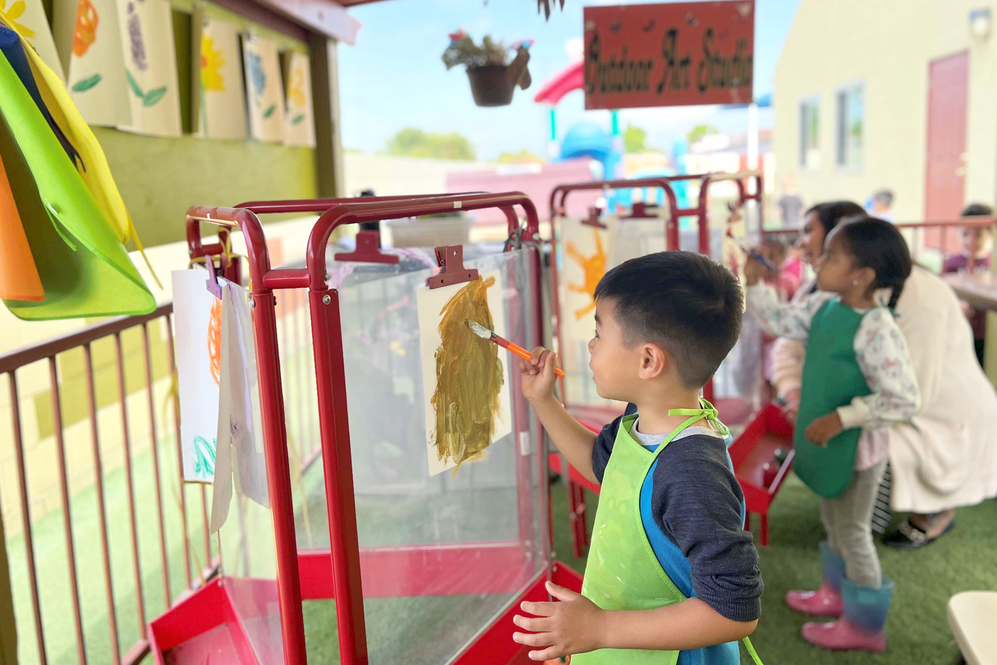 Teacher leading Outdoor Art in Anaheim Preschool with preschoolers
